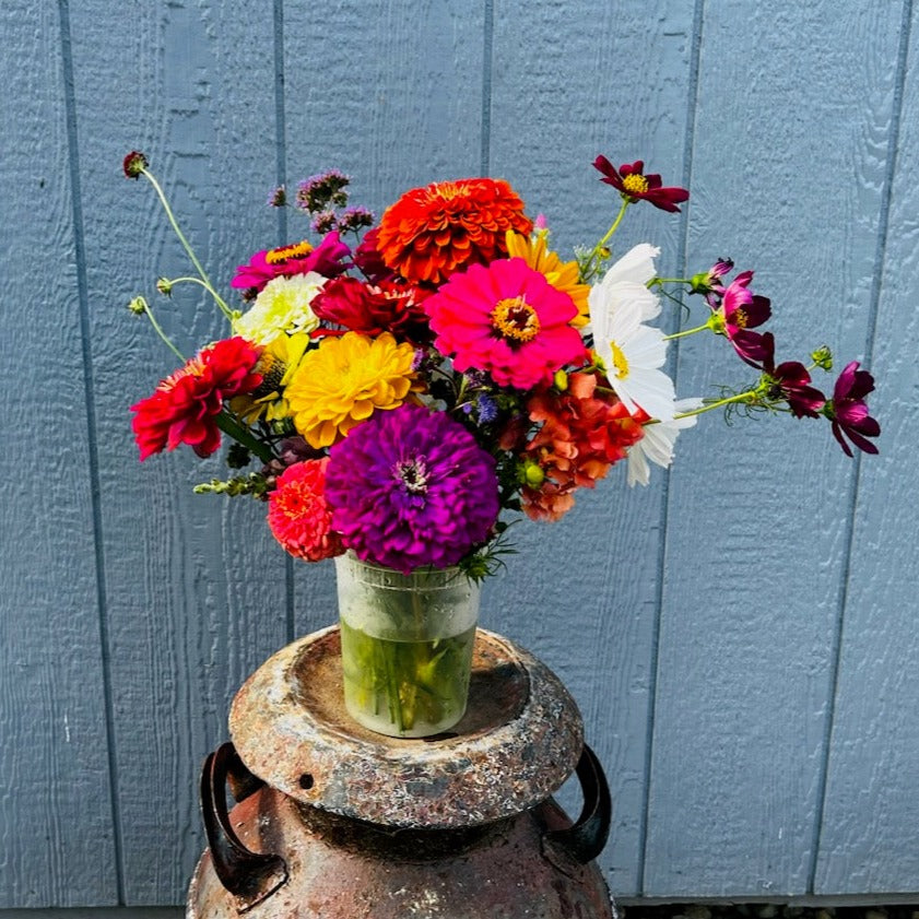 Colorful flower arrangement in a plastic bucket.