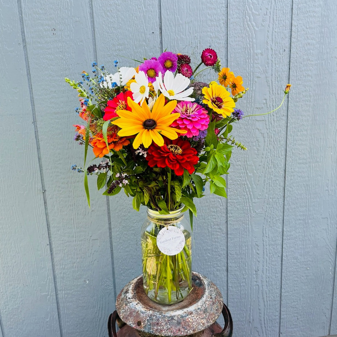 Arrangement of brighly colored wildflowers in a mason jar.