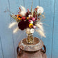 A 16oz mason jar filled with dried flowers on display at a farm.